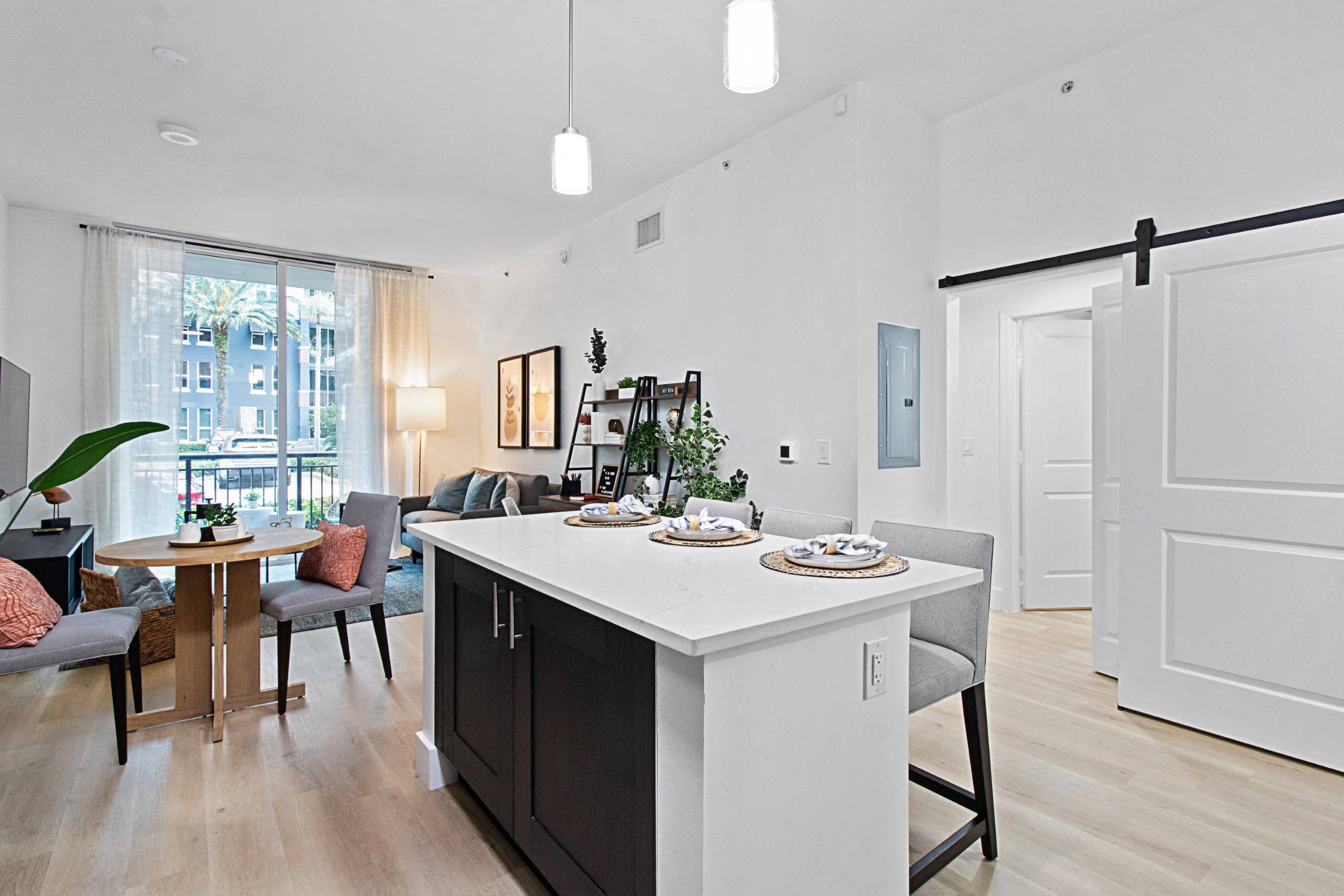 a kitchen with an island and a living room with a table and chairs